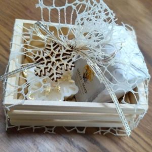 Darilni zabojček z naravnim milom, dišečo svečko in lesenim okrasom. Popolno ročno izdelano darilo za praznike in posebne priložnosti.