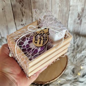 Darilni zabojček z naravnim milom, dišečo svečko in lesenim okrasom. Popolno ročno izdelano darilo za praznike in posebne priložnosti.