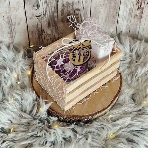 Darilni zabojček z naravnim milom, dišečo svečko in lesenim okrasom. Popolno ročno izdelano darilo za praznike in posebne priložnosti.