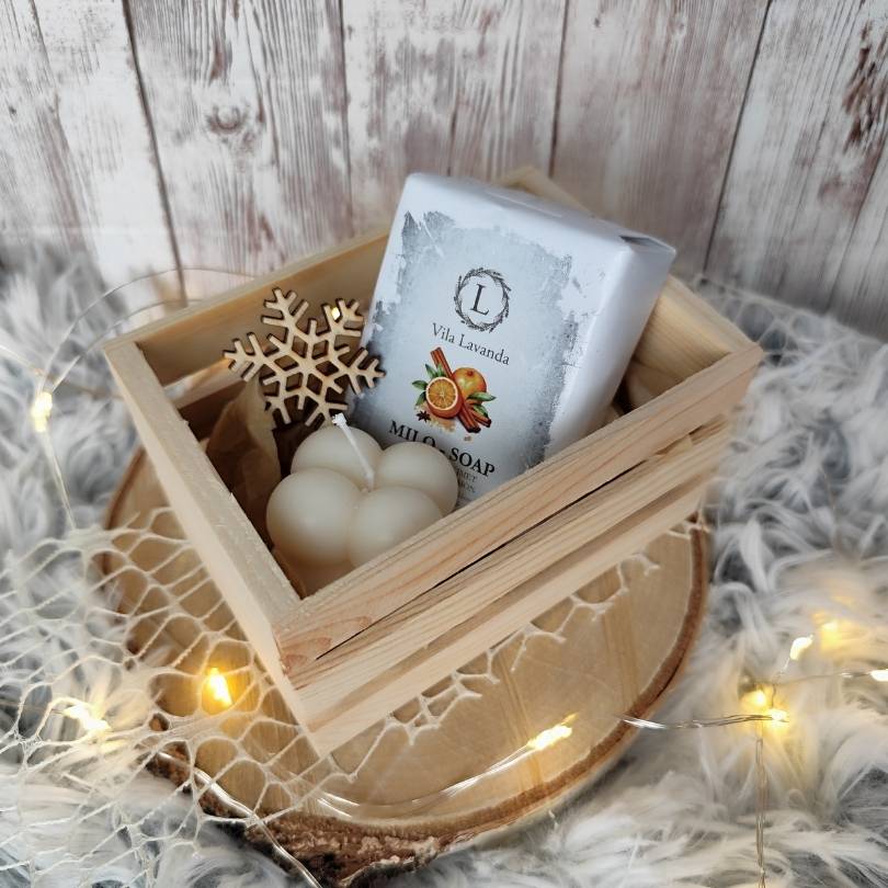 Darilni zabojček z naravnim milom, dišečo svečko in lesenim okrasom. Popolno ročno izdelano darilo za praznike in posebne priložnosti.