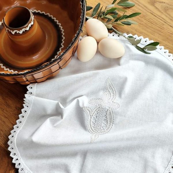 Ročno izdelan velikonočni prtiček z nežno klekljano čipko. Ovalna oblika in klekljan motiv križa s plameni. Možna izdelava v velikosti po naročilu.